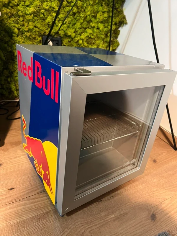Mini nevera con la puerta de cristal sobre un suelo de madera